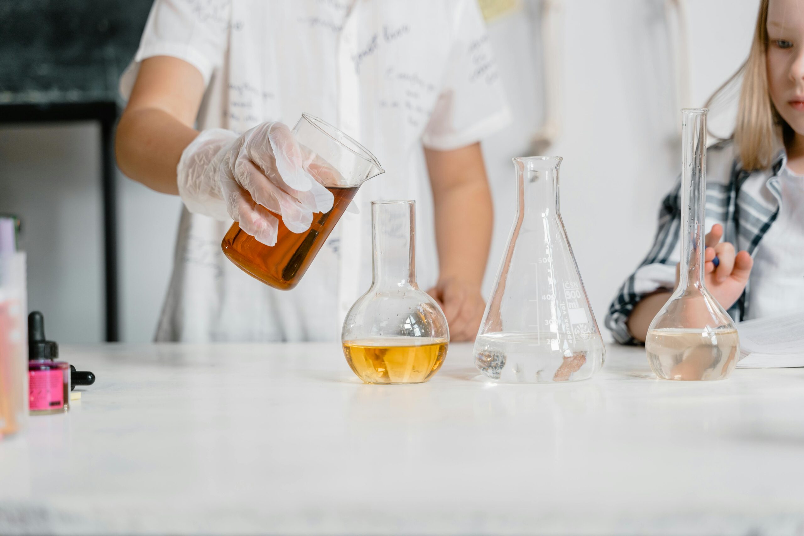 Children in a science lab conducting an experiment with beakers and liquids.